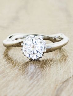 a diamond ring sitting on top of a wooden table