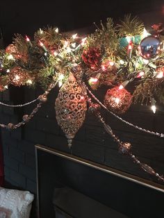 christmas decorations hanging from the ceiling in a room with brick walls and lights on it