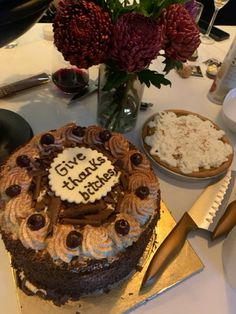 there is a cake on the table with flowers in the vase and another plate next to it