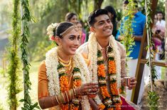 a man and woman dressed in flower garlands