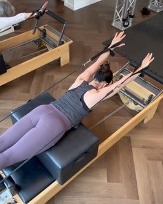 a woman is doing exercises on an exercise machine