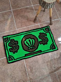 a green rug with dollar signs on it in the middle of a floor next to a stool