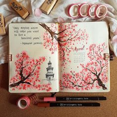 an open book with pink flowers and writing on it