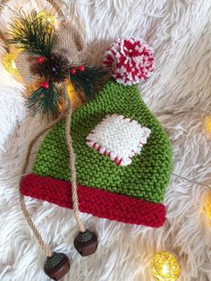 a knitted christmas hat with pom - poms and bells on white fur