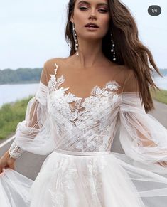 a woman in a white dress is posing for the camera