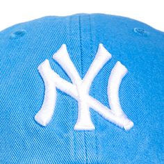 the new york yankees logo on a blue baseball cap with white stitching and an adjustable visor