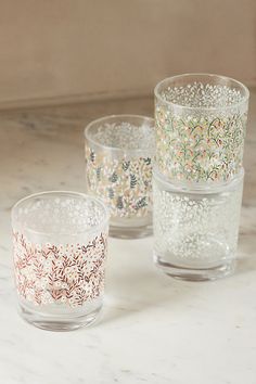 three glass cups sitting on top of a marble counter