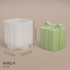 a green box with a bow on the top and a white box with a bow on the bottom