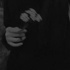 black and white photograph of someone holding a flower in their hand with the word love written on it