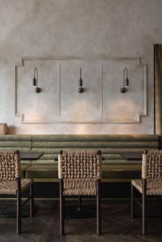 two tables and four chairs in front of a wall with three lamps on each side