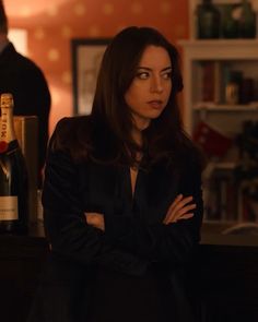 a woman standing in front of a bar with her arms crossed