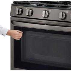 a woman is opening the oven door to show it's new stainless steel finish