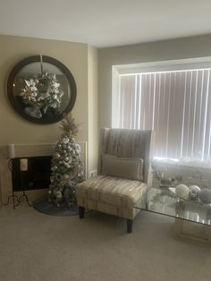 a living room with a christmas tree in the corner and a chair next to it