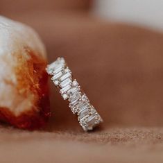 a diamond ring sitting on top of a piece of fruit