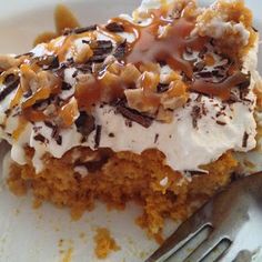 a piece of cake with whipped cream and nuts on top is sitting on a plate next to a fork