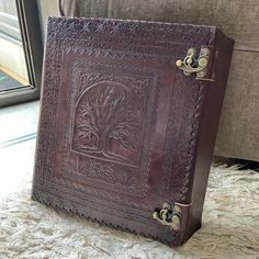 a brown leather book sitting on top of a white rug