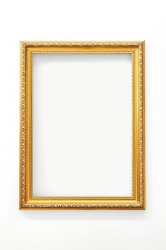 an empty gold frame on a white wall with clipping area for text or image