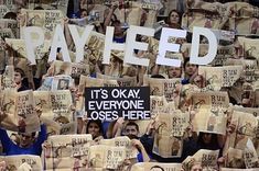 a group of people holding up newspapers with the words payered written on them in white letters