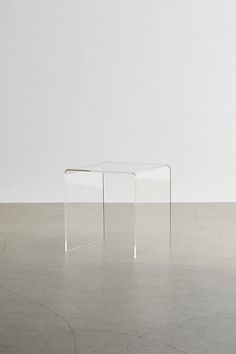 two clear tables sitting on top of a cement floor