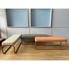 two benches sitting next to each other on top of a hard wood floored floor