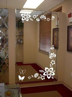 a mirror with flowers and butterflies on it in a hallway next to a wall mounted art piece