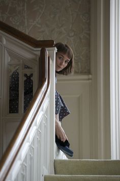 a woman is walking down the stairs in her house