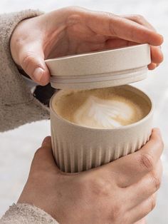 a person holding a cup with foam in it