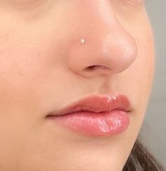 a close up of a woman's nose and nose piercing