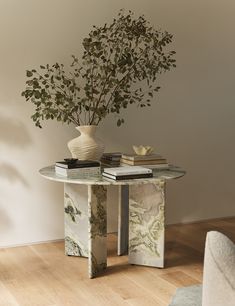 a glass table topped with books and a vase filled with flowers on top of it