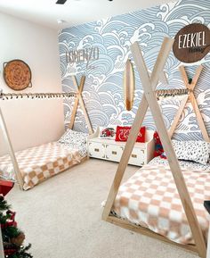 two beds in a room with blue and white wallpaper, one is made from wood