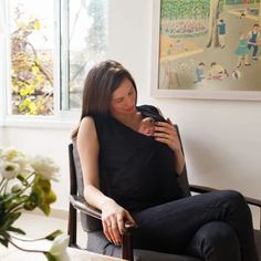 a woman sitting in a chair looking at her cell phone