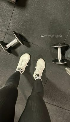 a person with white shoes and black pants standing in front of a gym equipment machine