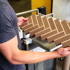 a man is working with some wood in his hand and making something out of it