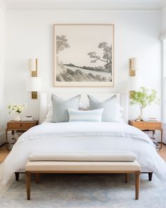 a bed with white sheets and pillows in a bedroom next to a painting on the wall