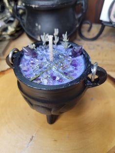 a pot with some flowers in it on top of a wooden table next to other items