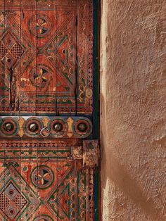 an ornate wooden door with decorative designs on the front and side doors are painted in different colors