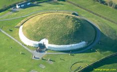 an aerial view of a large circular structure in the middle of a green field