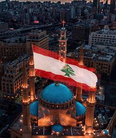 an aerial view of a large building with a flag on it's roof at night