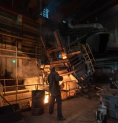 a man standing in front of a metal furnace