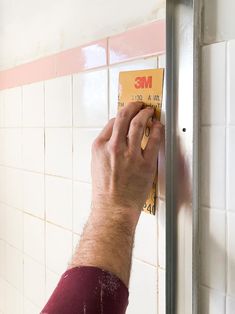 a man is using a magnet on the wall to fix a bathroom faucet