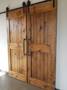 two wooden doors with metal handles in a room