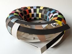 several strips of black, white, and multicolored paper are stacked on top of each other