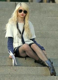 a woman sitting on some steps with her legs crossed wearing fishnet stockings and thigh high boots