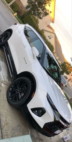 a white sports car is parked on the curb