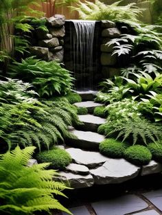 a small waterfall in the middle of a garden with lots of green plants and rocks