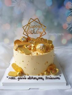 a birthday cake with gold decorations on top