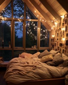 a bedroom with lights hanging from the ceiling and a bed in front of a window