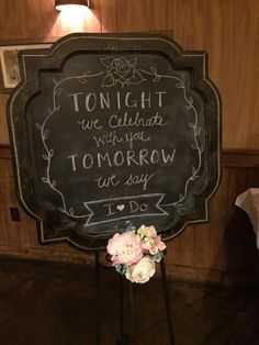 there is a sign that says tonight we celebrate tomorrow with flowers in front of it