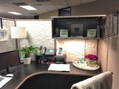 an office cubicle with a desk, chair and computer