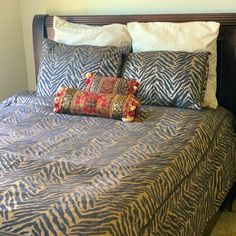 a zebra print bed spread with pillows on it